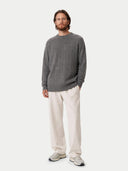 front view of a man wearing a gray square patterned sweater and beige pants on a white background #color_dim-gray