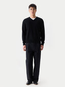 Man wearing a black v-neck sweater and pants on a white background #color_black