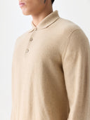 Beige long-sleeve cashmere polo worn by a person on a light gray background.