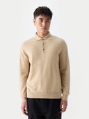 Man wearing a beige sweater against a white background