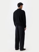 Person standing back wearing a black outfit on a white background #color_black