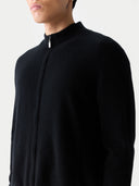 There is a close-up picture. Person wearing a black long-sleeve shirt with a high collar on a light gray background #color_black