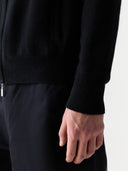 There is a close-up of the cardigan sleeve  and black pants #color_black