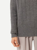 a zoomed-in shot of square patterned sweater sleeve #color_dim-gray
