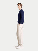 back view of a navy sweater and white pants on a light gray background #color_navy-blazer