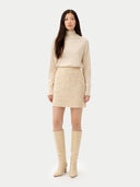 Woman wearing a beige sweater, skirt, and knee-high boots on a white background #color_off-white