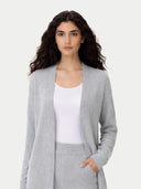 Woman wearing a gray cardigan over a white top on a light gray background #color_high-rise