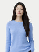 Woman wearing a light blue sweater against a white background #color_della-robbia-blue