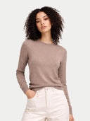Woman wearing a brown sweater and white pants on a light gray background #color_timber-wolf