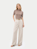 front view of a woman wearing a brown top and beige pants on a white background #color_timber-wolf