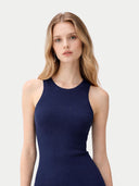 Woman wearing a navy blue sleeveless dress on a light gray background #color_navy