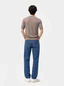 back view of a person wearing a brown shirt and blue jeans on a white background #color_timber-wolf