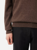 back view of a brown V-neck sweater  and black pants #color_cocoa