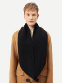 Man wearing a tan coat with a black quilted scarf on a white background #color_black