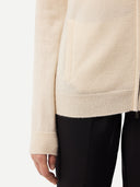 close up of a beige zip cardigan #color_off-white