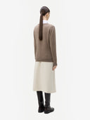 back view of a woman wearing a brown sweater and beige skirt on a white background #color_taupe