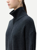 side view of a woman wearing a dark gray mock ribbed neck zip-up cardigan. #color_charcoal