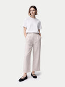 Woman wearing a white t-shirt and beige pants on a white background #color_black