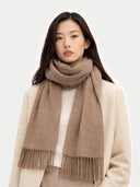 Woman wearing a beige scarf with fringe on a white background  #color_taupe