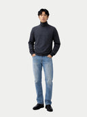 front view of a man wearing a dark turtleneck sweater and light blue jeans on a white background #color_charcoal