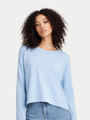 Woman wearing a light blue sweater and jeans on a plain background #color_aquamarine