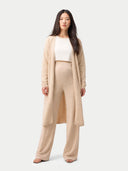 Woman wearing a beige cardigan and maternity pants set on a white background #color_beige