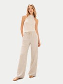 front view of a woman wearing a beige sleeveless top and wide-leg pants on a white background #color_off-white