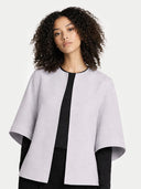 Woman wearing a light gray poncho over a black outfit on a white background #color_arctic-ice