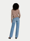 back view of a person wearing a beige sweater and blue jeans on a white background #color_taupe