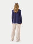front view of a woman wearing a navy cardigan and beige pants on a white background #color_crown-blue