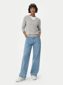 front view of a person wearing a gray sweater and light blue jeans on a white background #color_dawn-blue
