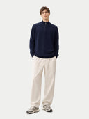 Man wearing a navy sweater and light-colored pants on a white background #color_navy