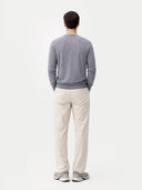 back view of a man wearing a gray sweater and white pants on a light gray background #color_dim-gray