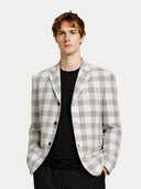 Man wearing a checkered blazer over a black shirt on a white background #color_off-white