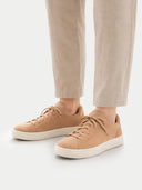 Tan sneakers worn with beige pants on a white background #color_toasted-almond