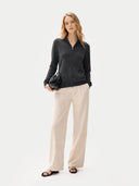 front view of a woman wearing a black sweater and beige pants on a white background #color_charcoal