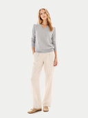 front view of a woman wearing a gray sweater and beige pants on a white background #color_high-rise