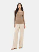 Woman wearing a brown sweater and beige pants on a white background #color_timber-wolf
