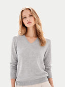 Woman wearing a gray v neck sweater on a light gray background #color_high-rise