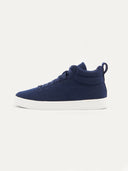 side view of a high-top sneaker featuring a navy textured upper with matching navy laces. The shoe has a padded collar, a pull tab at the heel, and a thick white rubber sole, shown from a three-quarter angle against a plain white background. #color_navy