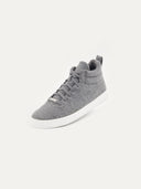 A high-top sneaker featuring a gray textured upper with matching gray laces and a small silver brand plate at the base of the tongue. The shoe has a padded collar, a pull tab at the heel, and a thick white rubber sole, shown from a three-quarter angle against a plain white background.#color_stone-gray