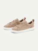 A pair of beige low-top cashmere ankle sneakers with white soles. #color_taupe