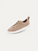 A three-quarter view of a low-top sneaker featuring a heather beige felted or textured knit upper with matching beige laces. The shoe includes a small silver brand plate at the base of the tongue, a gray pull tab at the heel, and a thick, solid white rubber sole, set against a plain light background.
#color_taupe