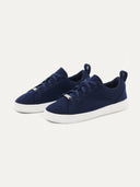 A pair of navy blue low-top cashmere ankle sneakers with white soles.  #color_navy
