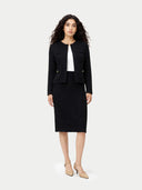 Woman wearing a black suit with a white top on a white background #color_black