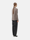 back view - woman wearing a light brown polo sweater and black pants #color_stucco