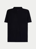 back view of black polo shirt with white trim on a light gray background #color_black