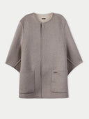 flat lay of a gray beige poncho with side pockets