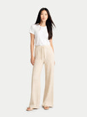 Woman wearing a white top and beige wide-leg pants on a white background #color_off-white