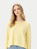 Woman wearing a yellow sweater against a light gray background #color_green-sheen